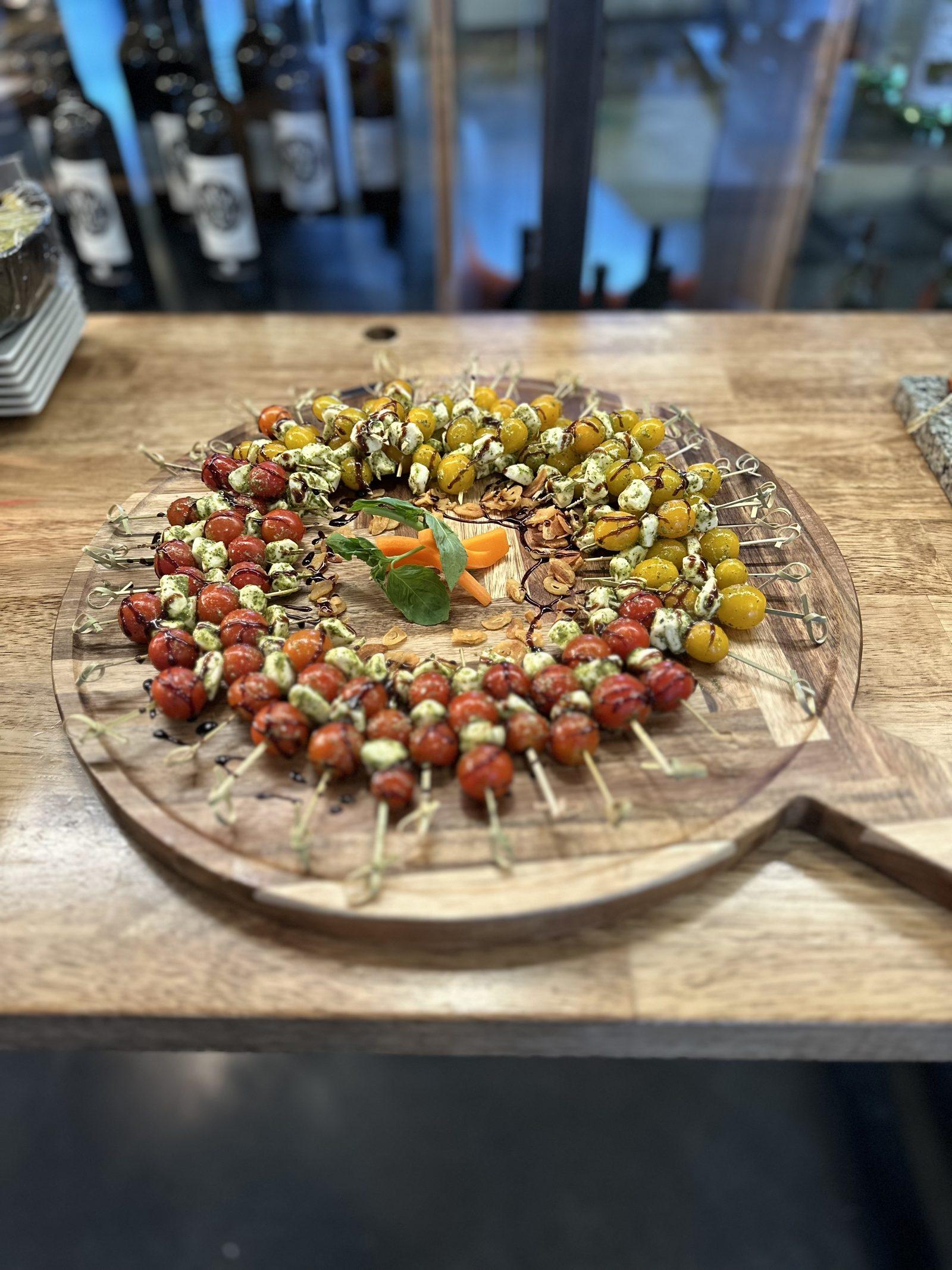 Caprese tomato and mozzarella skewers arranged on a wooden board for a cocktail party