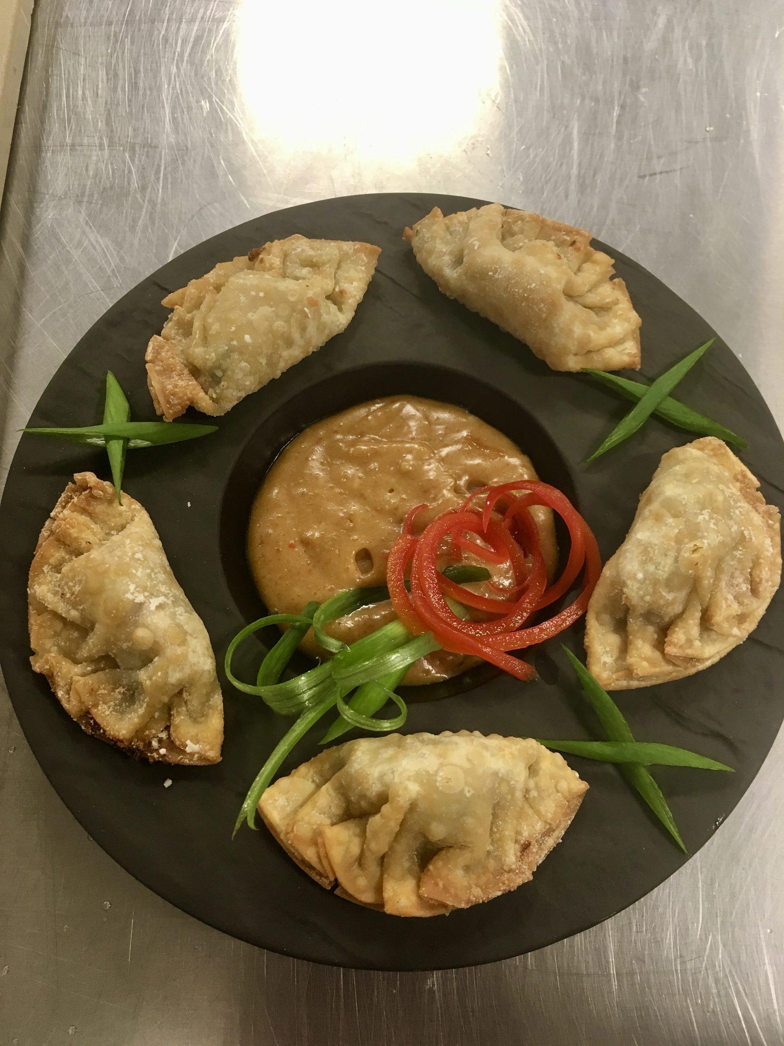 Crispy plated appetizers with dipping sauce, prepared for a vacation-home dinner