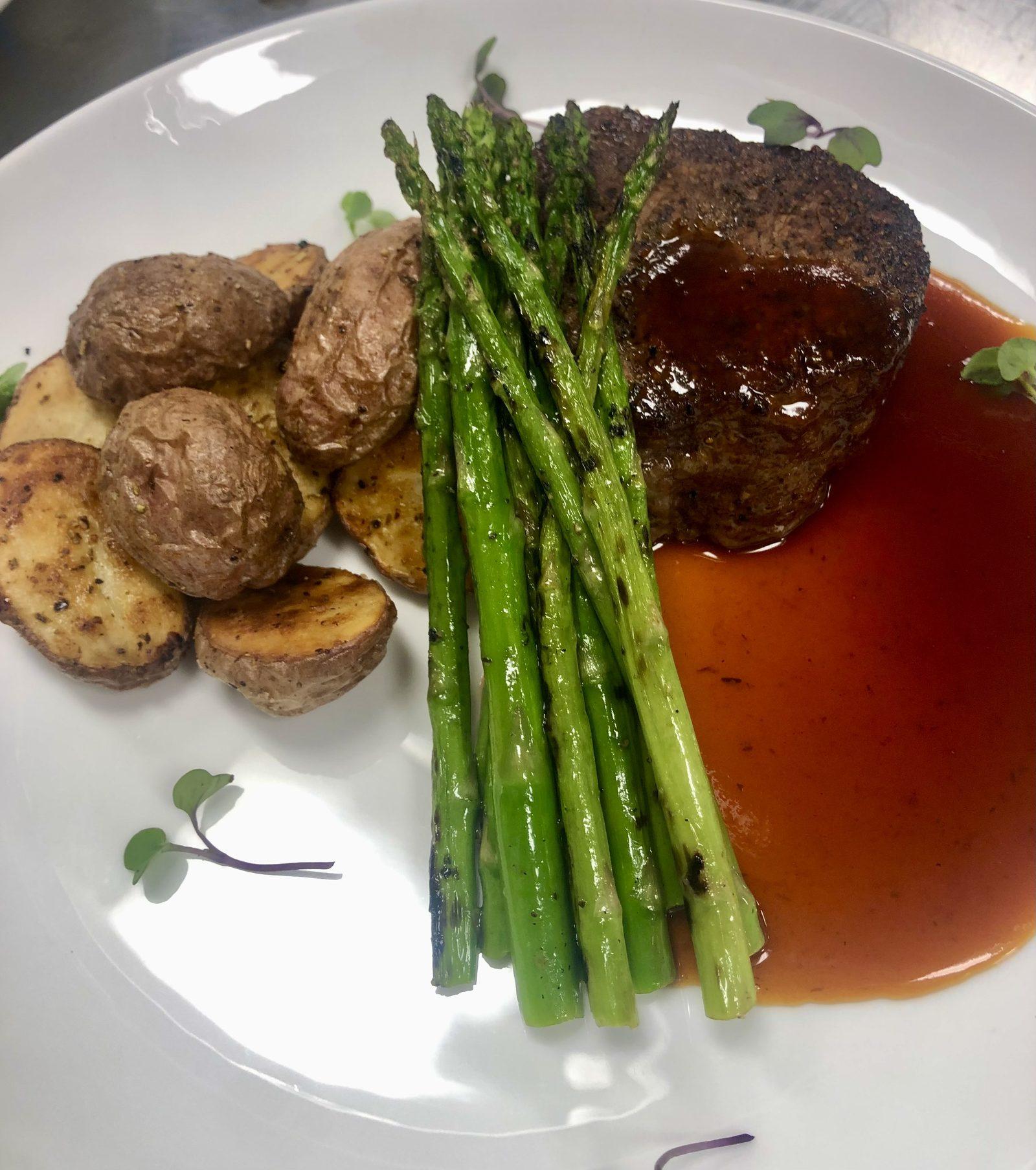 Cast-iron seared beef tenderloin with lobster tail, asparagus, and roasted potatoes